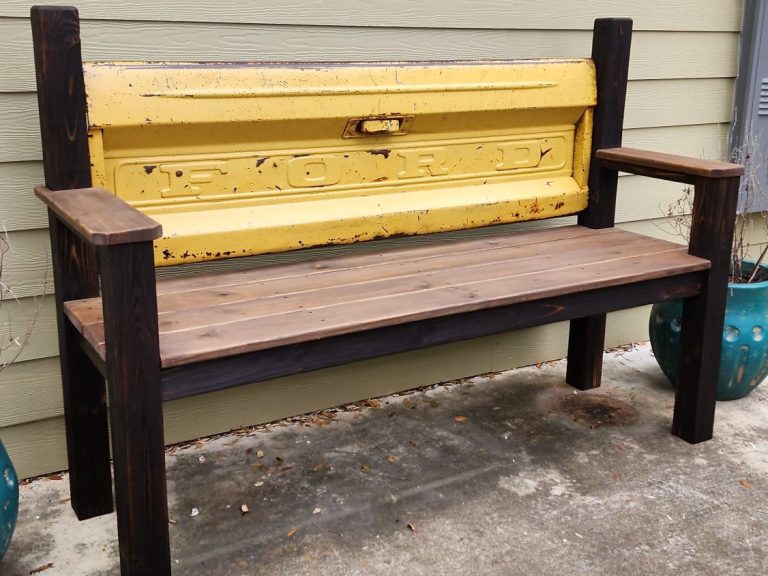 Classic pickup truck tailgate bench with a dark frame and light-colored wooden seat.