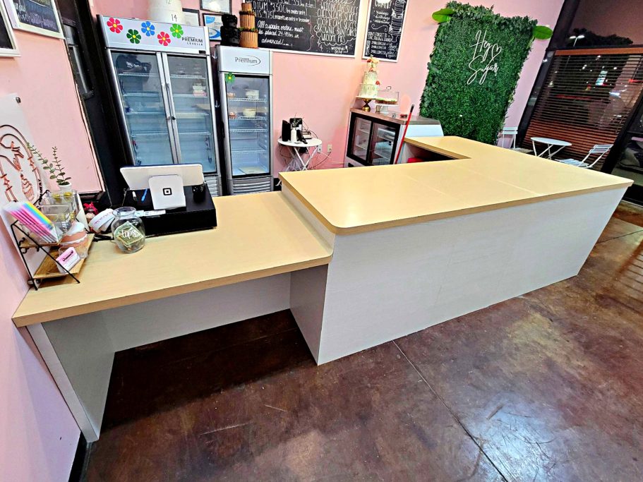 Custom café service counter with wood countertop and white panel base