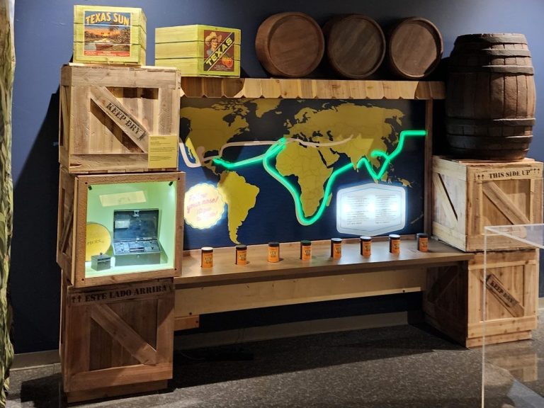 Spice Routes Exhibit Completed Spice Routes display with a world map, barrels, crates, shelving, and a counter.