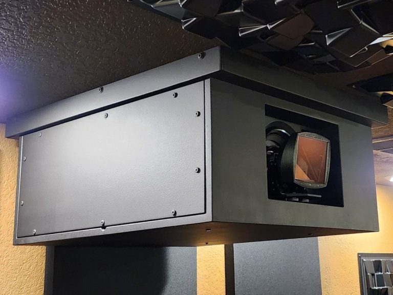 Projector enclosure mounted on a ceiling with lens opening