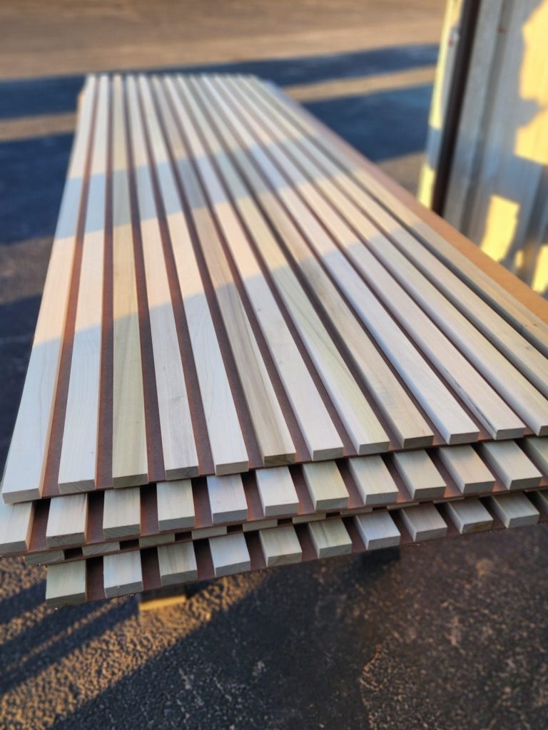 Long parallel wood slats assembled into a rectangular feature on an outdoor surface.
