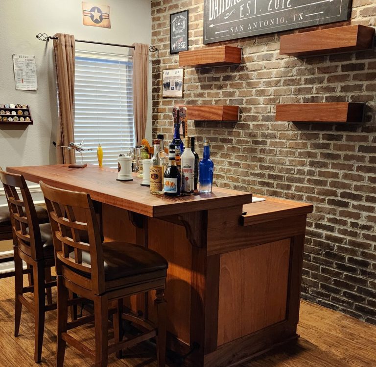 Wood bar and stools in front of a brick wall with floating wood shelves.