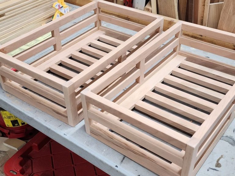 Several unfinished produce drawers arranged on a work table.
