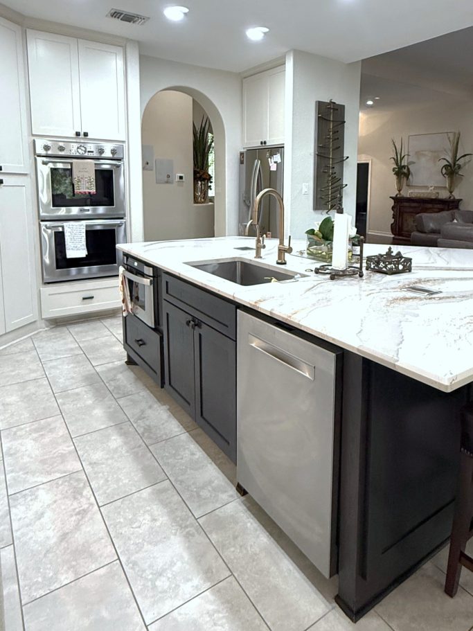 Large kitchen island cabinetry with dark cabinet base and stone countertop