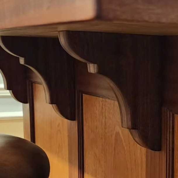 Decorative wooden corbels supporting the underside of a counter or shelf.