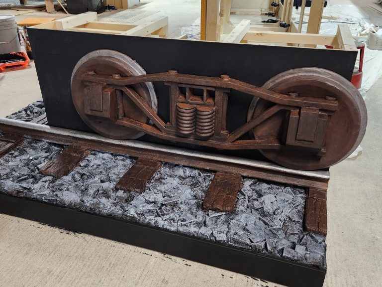 Ice Reefer Car Wheel Assembly Wooden wheel assembly mounted above the model track and gravel base.