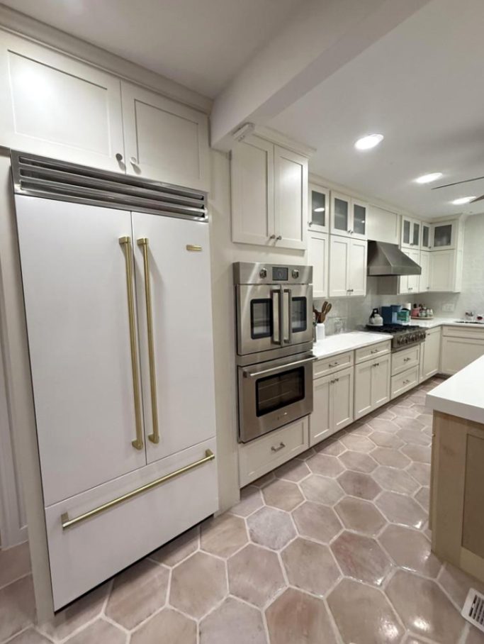Custom white kitchen cabinetry with built-in storage and tiled backsplash