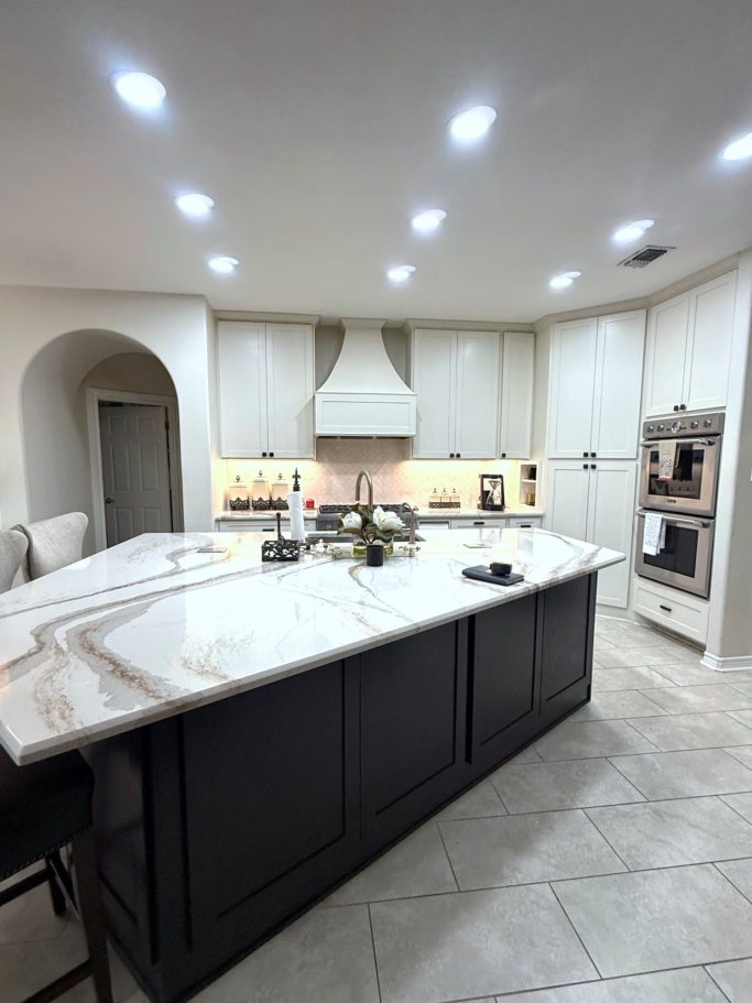 Two tone kitchen with dark island cabinetry and light perimeter cabinets
